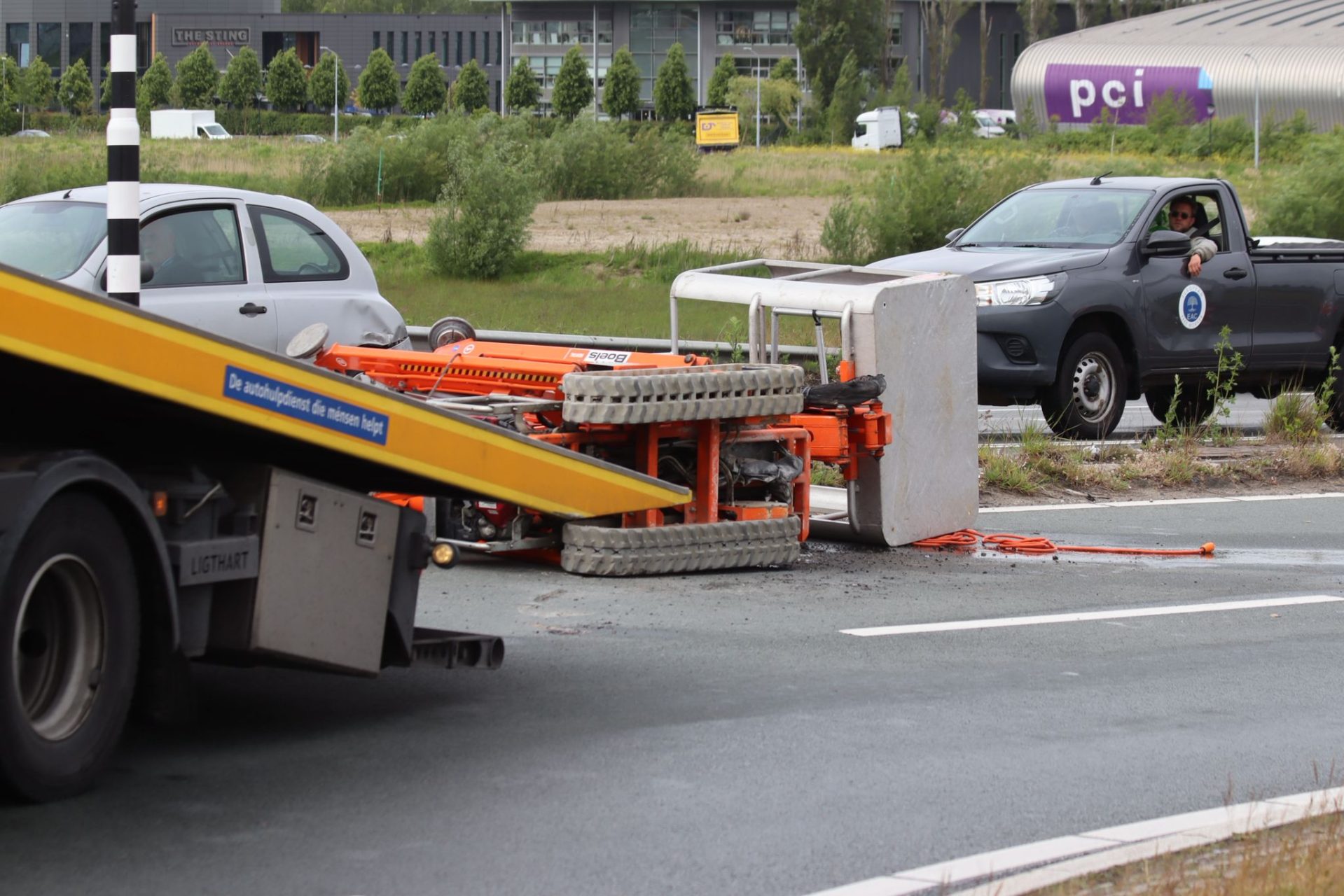 Mini hoogwerker valt van trailer in bocht, weg tijdelijk afgesloten