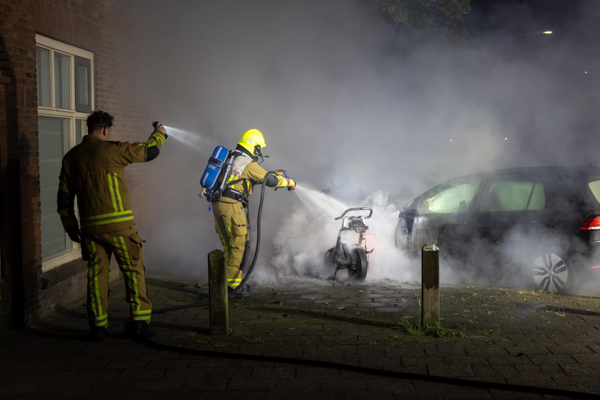 Auto en scooter in lichterlaaie bij aankomst van brandweer