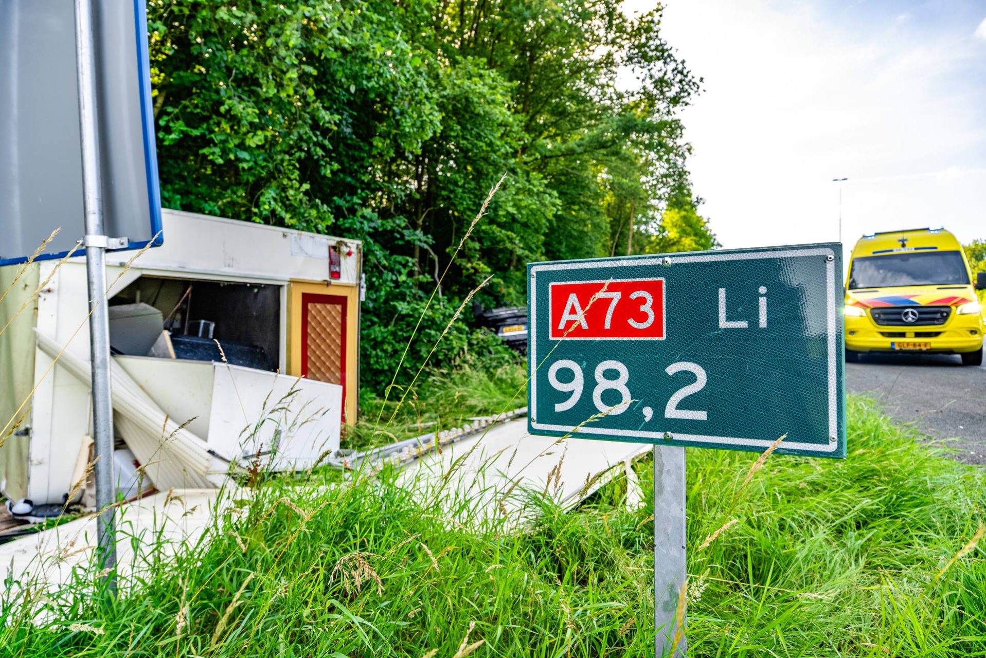 Auto met aanhanger ondersteboven in berm na crash